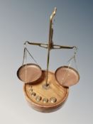 A set of precision balance scales on turned wooden base with weights,