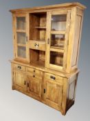 A contemporary oak dresser with glazed cupboards above,