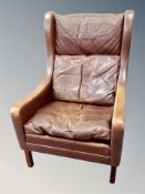 A mid 20th century Danish brown leather wing backed armchair,