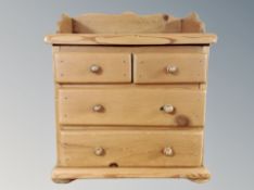 A miniature pine Victorian style four drawer chest