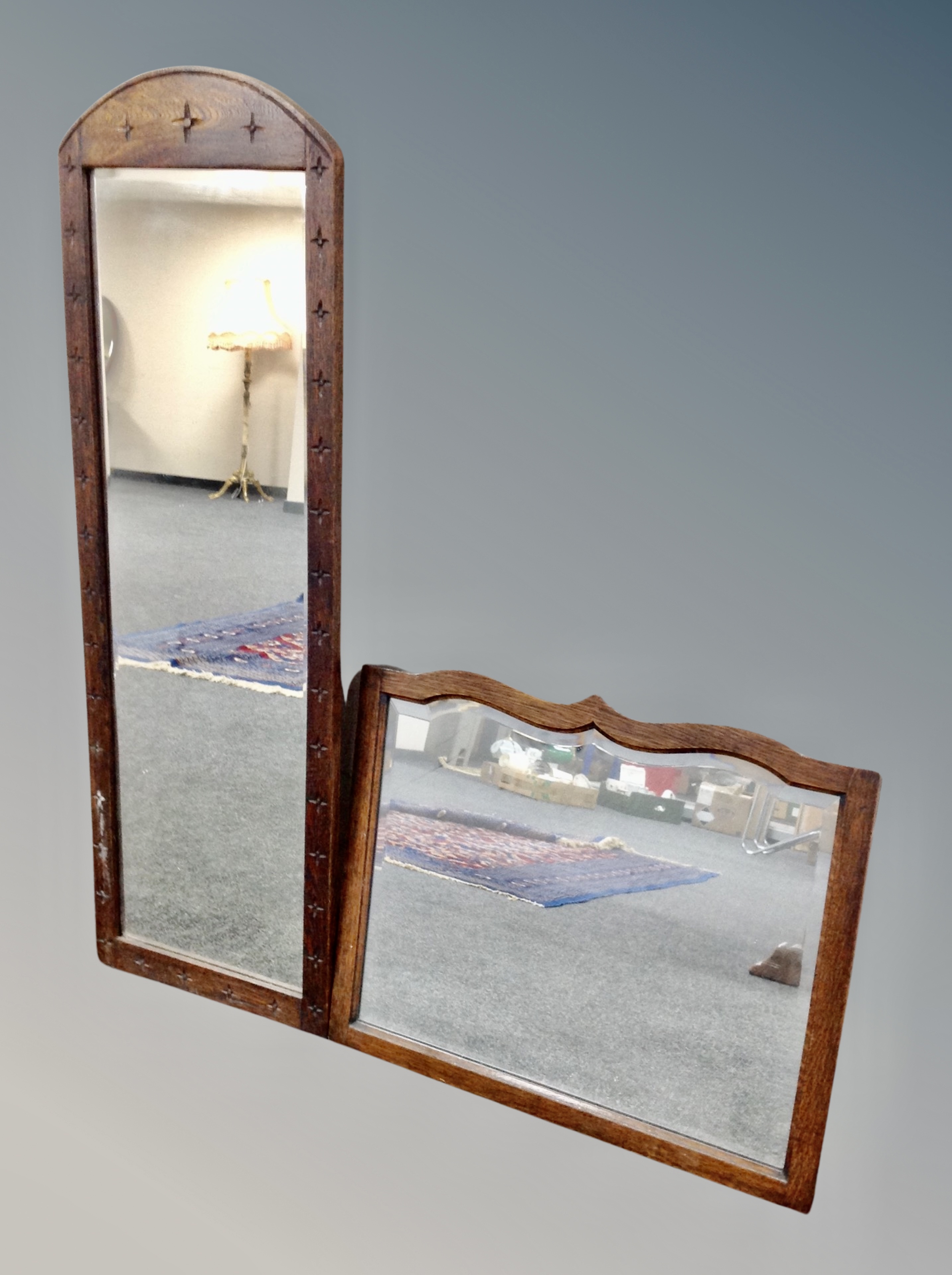 An Edwardian oak framed shaped bevelled mirror together with a further hall mirror