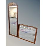 An Edwardian oak framed shaped bevelled mirror together with a further hall mirror
