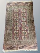 An antique Bokhara rug, Afghanistan, with repeat gul motif on claret ground,