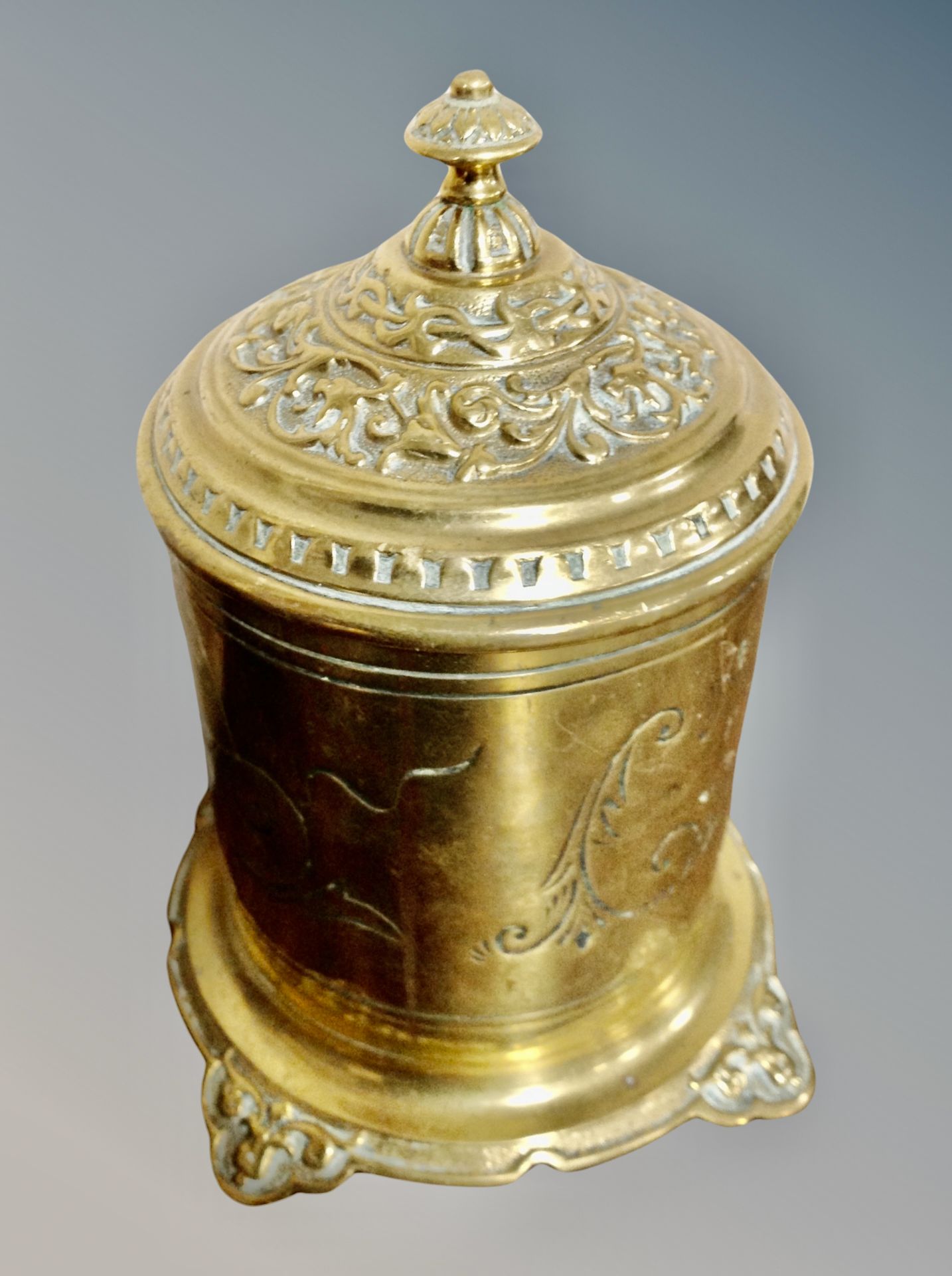 An embossed brass lidded tobacco jar