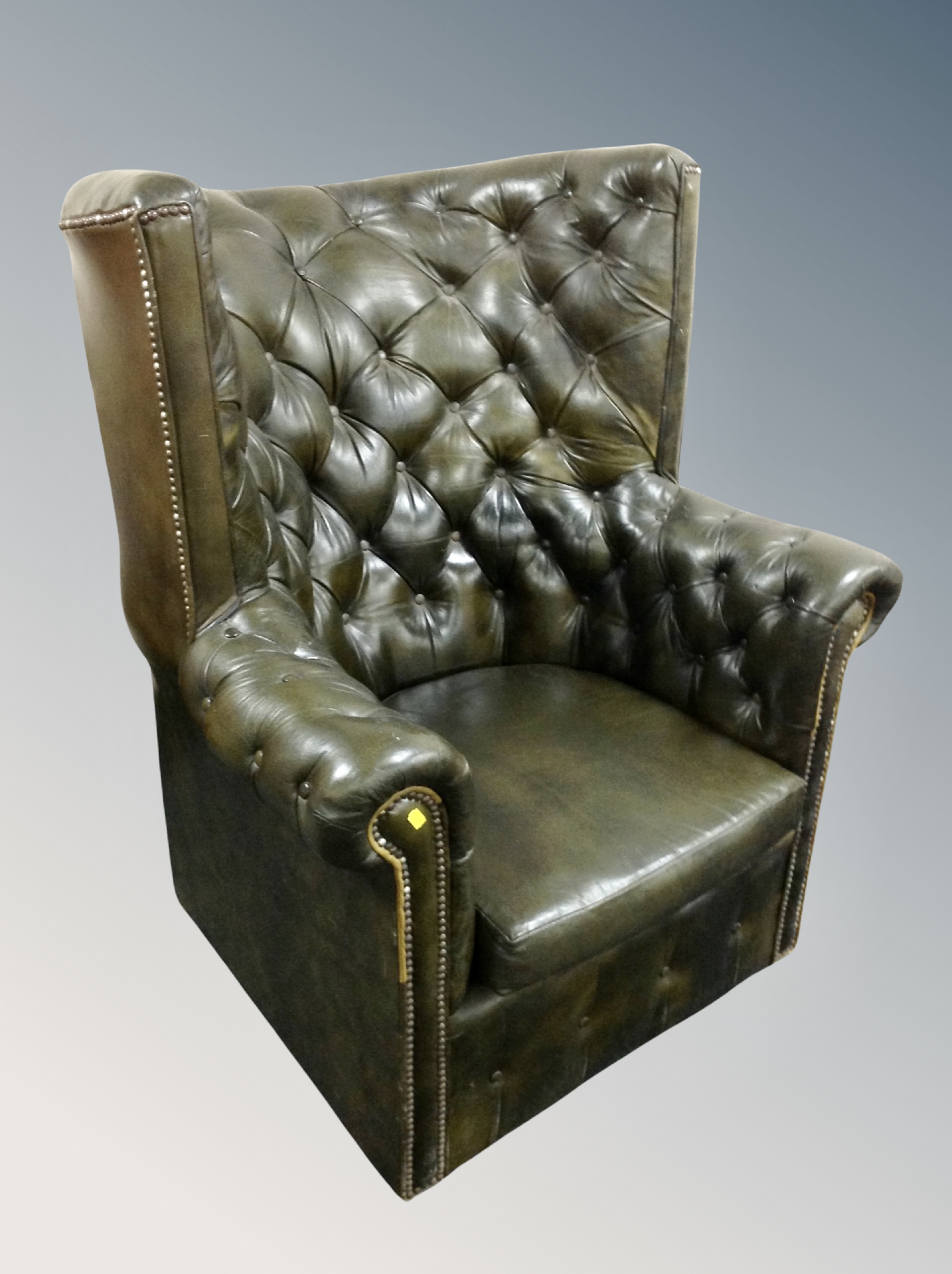 A Chesterfield green buttoned leather high backed armchair