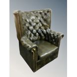 A Chesterfield green buttoned leather high backed armchair