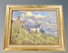 An oil on board depicting meadow grass with dwellings beyond, signed Henderson,