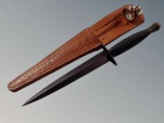 A reproduction Fairbairn-Sykes commando knife in a tooled leather sheath