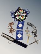 A box of assorted religious crosses, rosaries, pin badges, vintage hat pin,