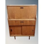 A mid century teak writing bureau fitted a drawer