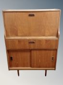 A mid century teak writing bureau fitted a drawer