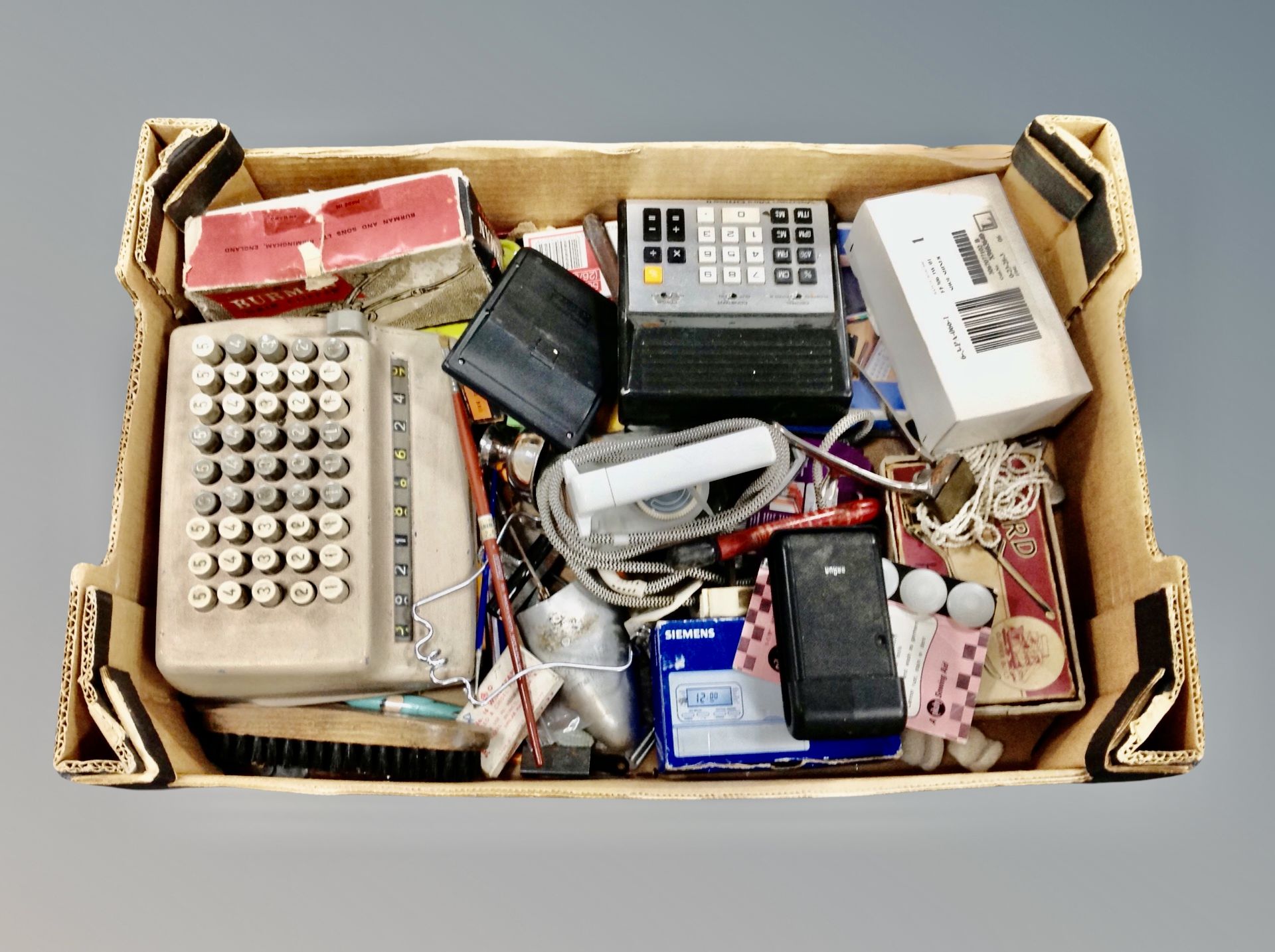 A box of shoe stretchers, adding machine, calculator, radio,