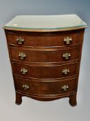 A mahogany Regency style bow fronted four drawer chest on bracket feet