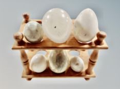 A pine egg rack and six marble and alabaster eggs