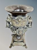 An antique bronze ornate urn on paw feet,