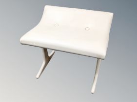 A 1970's cream vinyl upholstered dressing table stool on painted legs together with a vanity mirror