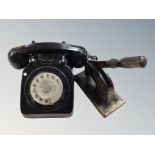 An old black telephone and cast iron company stamper