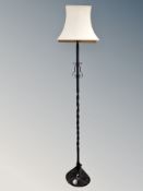 A wrought iron standard lamp with shade