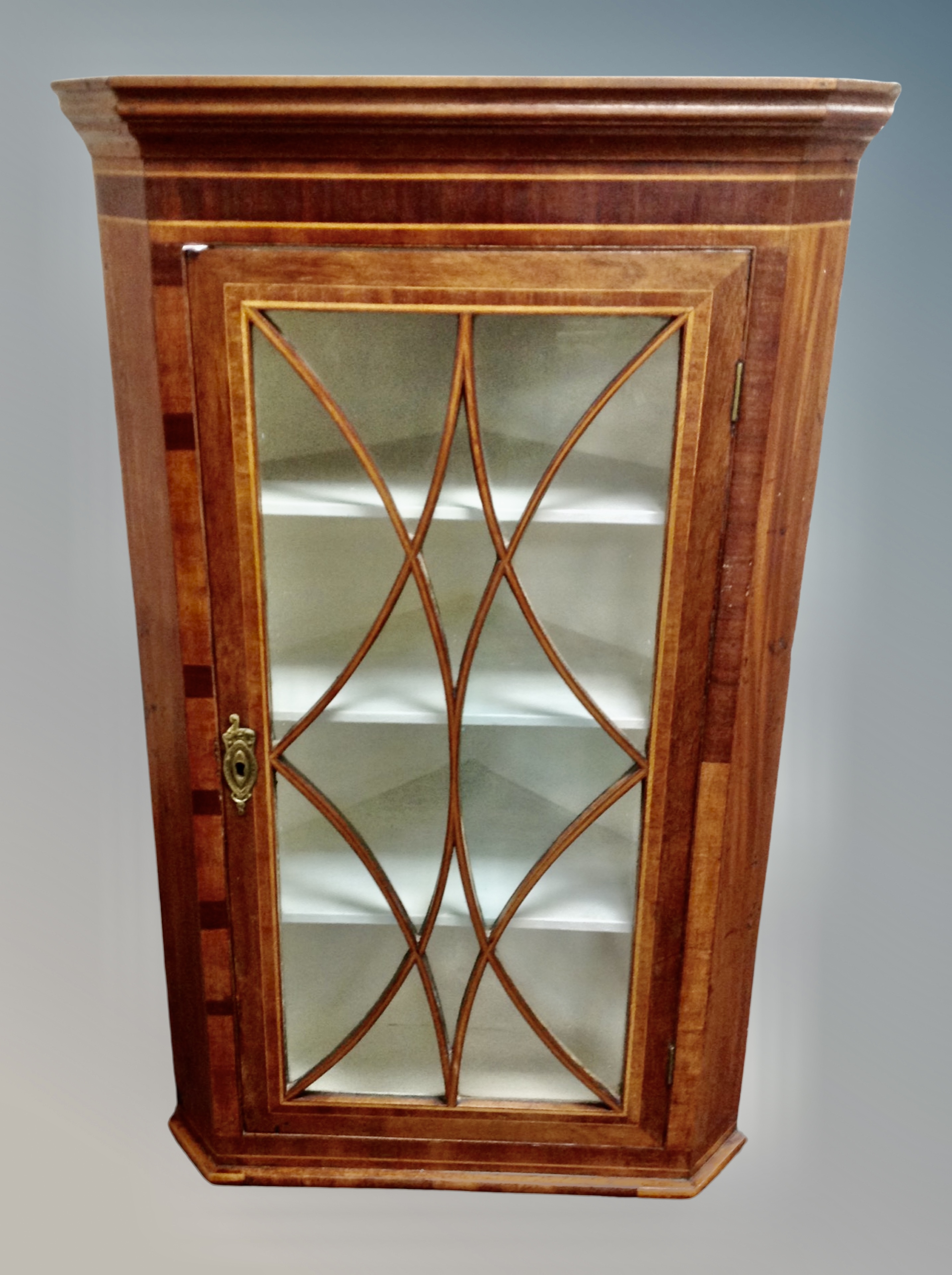 A 19th century inlaid mahogany glazed door corner cabinet