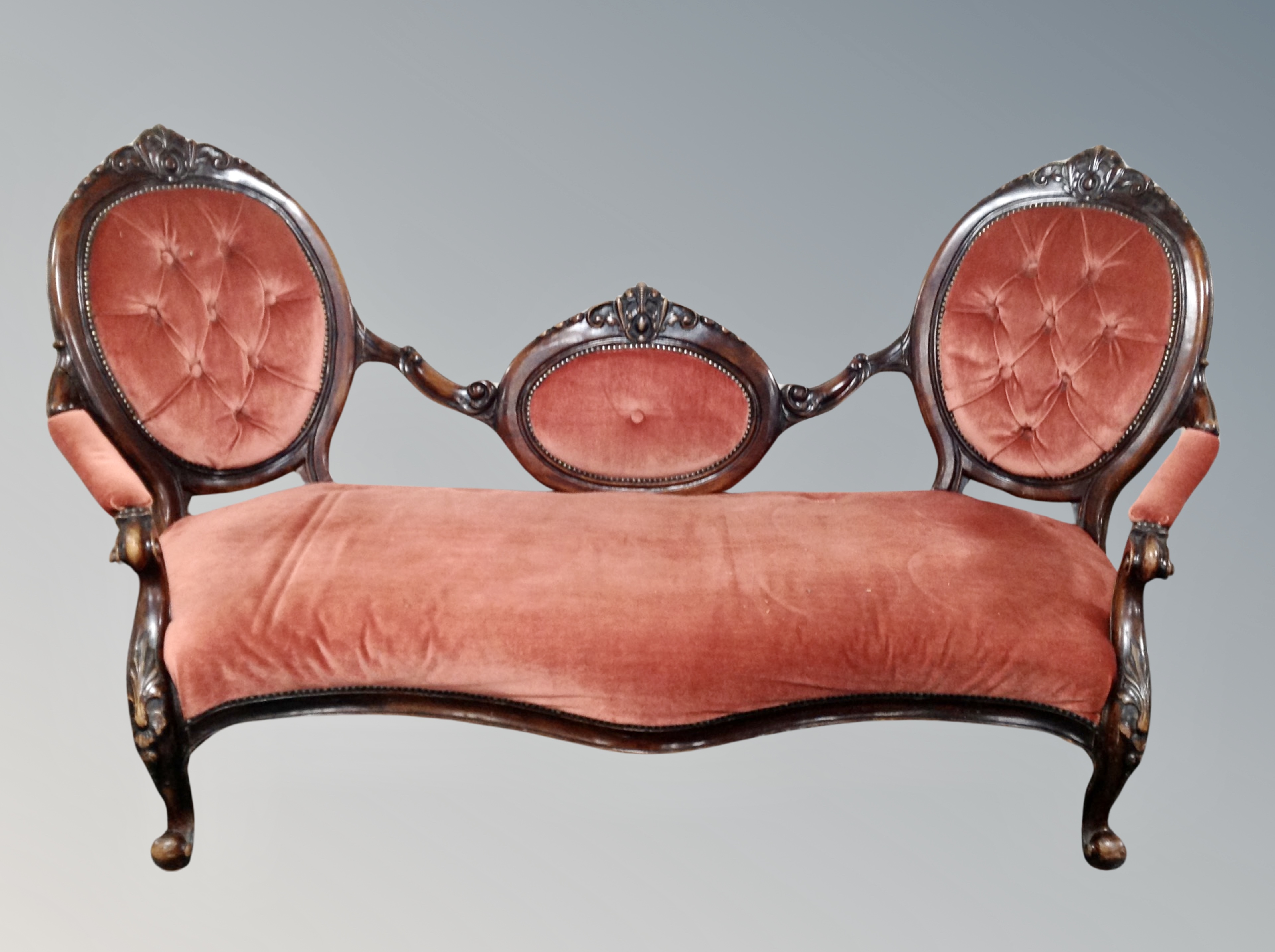 A Victorian carved mahogany salon settee in pink dralon