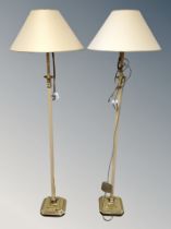 A pair of contemporary metal floor lamps on square brass bases with shades