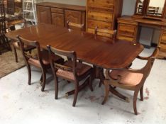 A Regency style inlaid mahogany twin pedestal dining table with leaf together with a set of six
