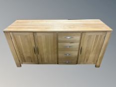 A contemporary oak triple door sideboard fitted with four drawers