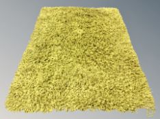 A contemporary green shaggy piled rug,