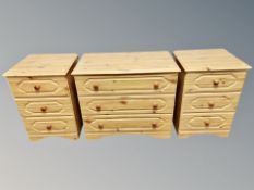 A contemporary pine effect three drawer chest and pair of matching bedside chests