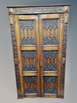 A 1920's carved oak double door wardrobe width 104 cm