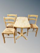 A pine drop leaf dining table together with three chairs