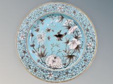 A Chinese turquoise ground porcelain plate, painted with a magpie amidst blossom,