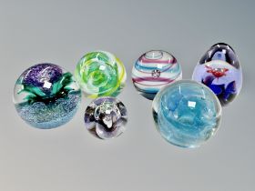 Six glass paperweights including Caithness