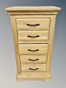 A contemporary oak narrow chest of five drawers,