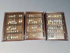 Three display cases containing a quantity of collector's spoons