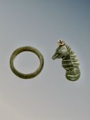 A green jade band ring and a seahorse pendant.