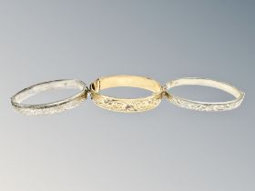 Two silver bangles and a further rolled-gold example.