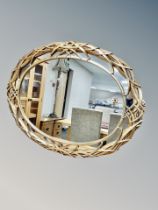 An ornate gilt framed oval overmantle mirror,