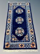 A Chinese rug on indigo ground 193 cm x 92 cm
