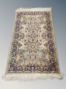 A machine made Persian-design rug on green ground 122 cm x 65 cm