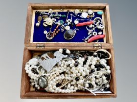 A carved trinket box containing costume jewellery, silver jewellery, pendants, earrings, brooches,