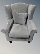 A contemporary wing backed armchair in grey