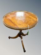 A mahogany tripod occasional table with brass gallery top,