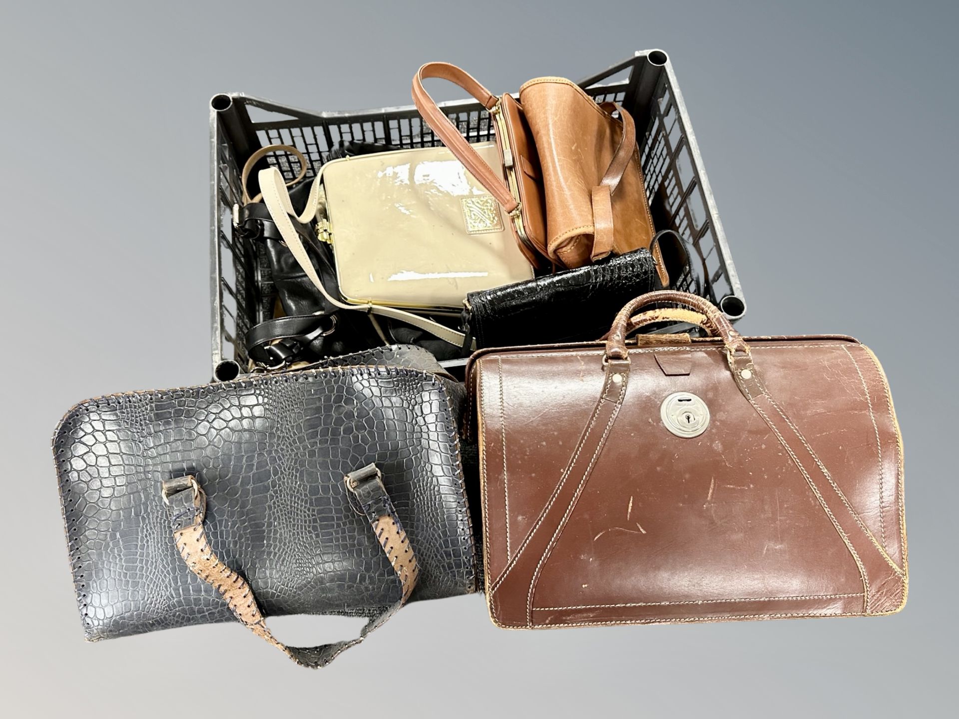 A vintage leather Gladstone bag together with a further crate of lady's hand and shoulder bags