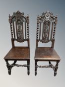 A pair of 19th century heavily carved oak hall chairs