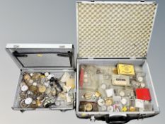 Two aluminium cases containing a group of horology items, wrist and pocket watch parts, movements,