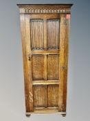 An Edwardian panelled oak linen fold single door hall cupboard,