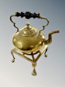 A brass kettle on stand with lion paw feet