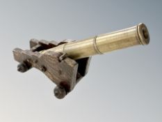 A brass desk cannon on wooden carriage,