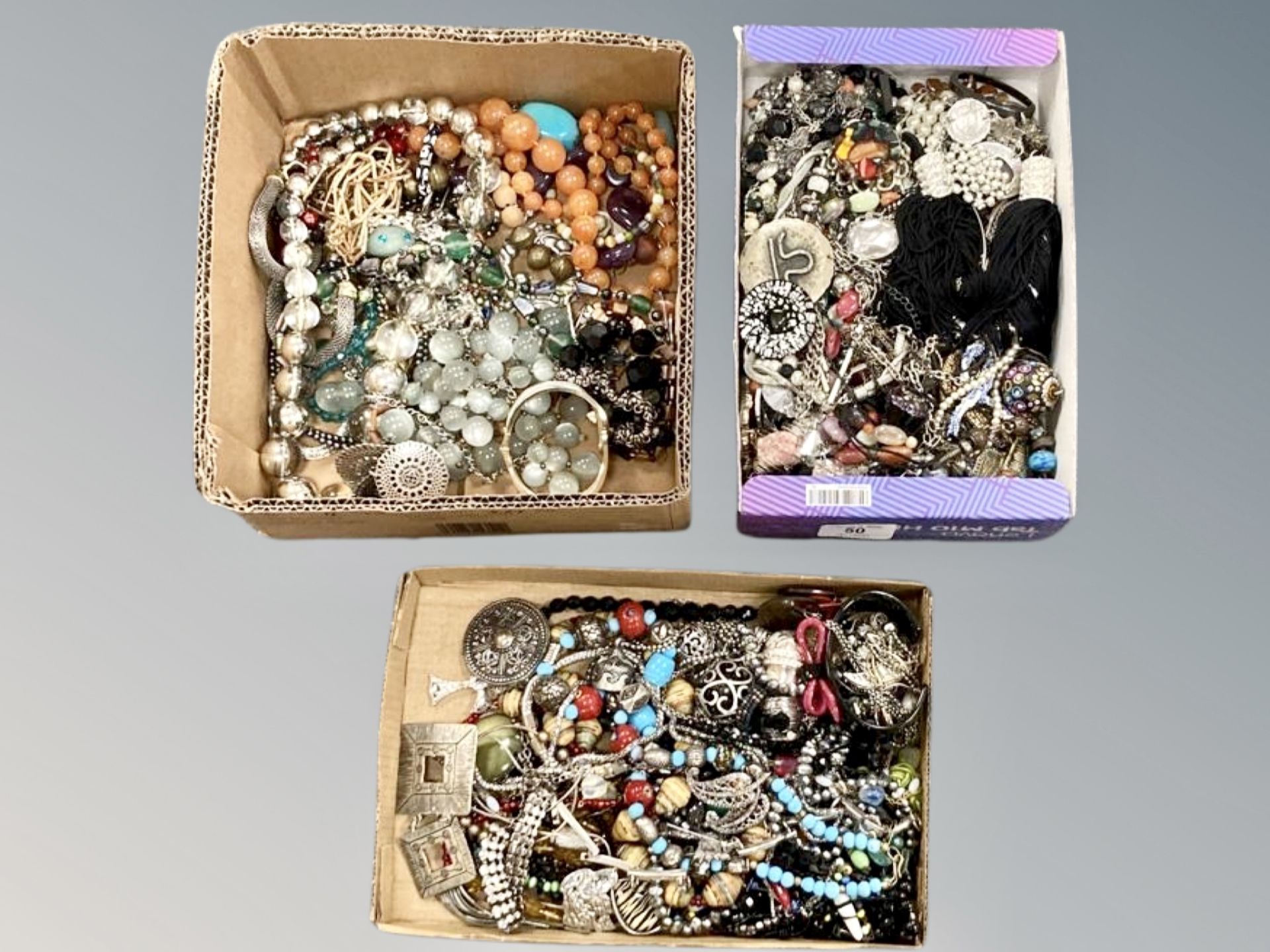 A collection of costume jewellery in three small boxes, beaded necklaces,